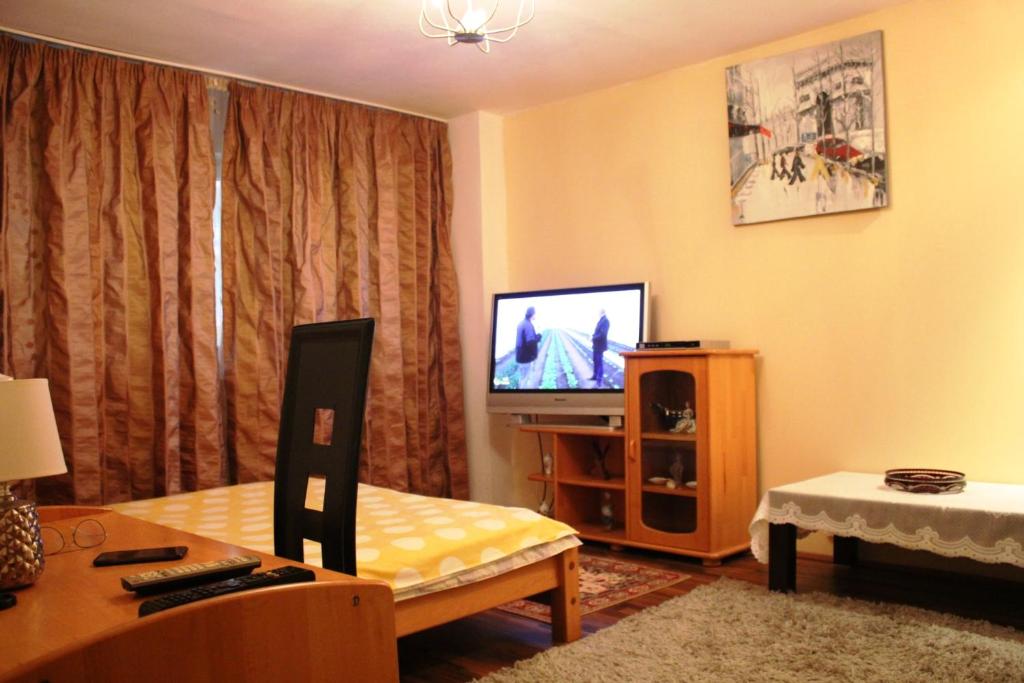 a living room with a tv and a couch and a table at Vitan modern apartment, sleeps 4 in Bucharest
