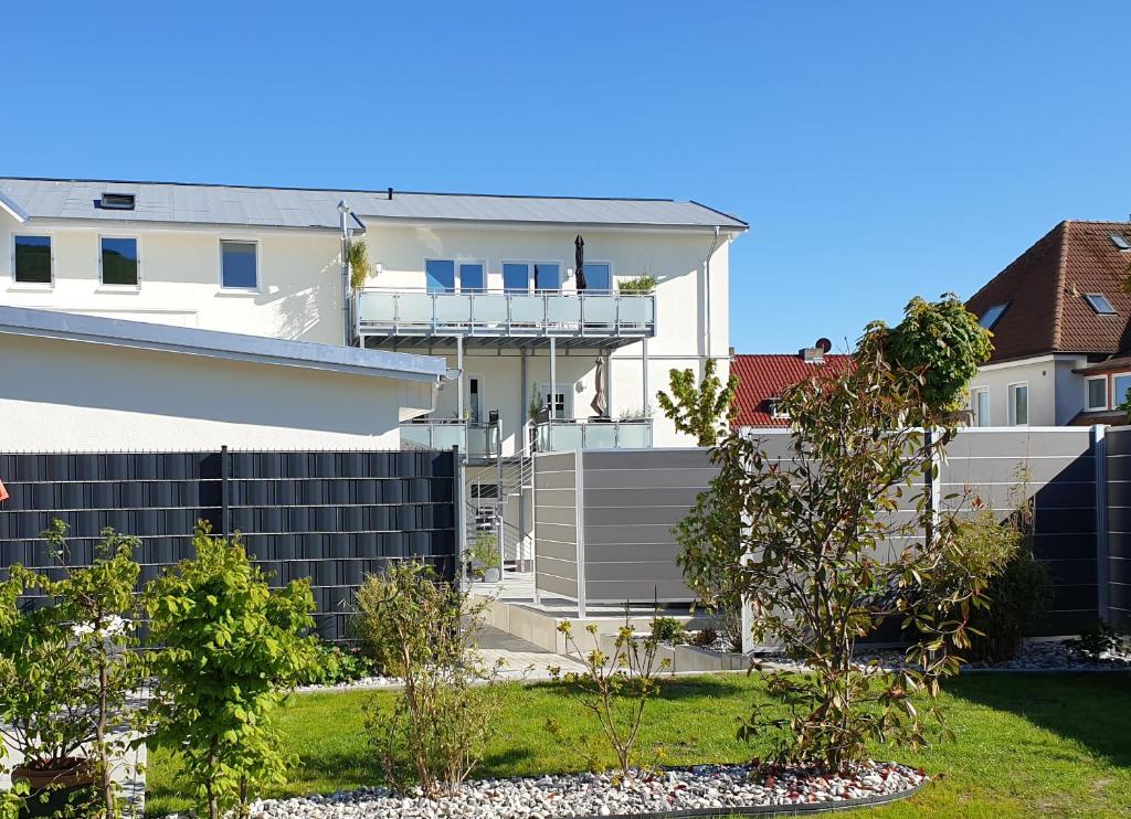 a white house with a fence in front of it at Urlaubsdomizil InselLust-Rügen in Sassnitz