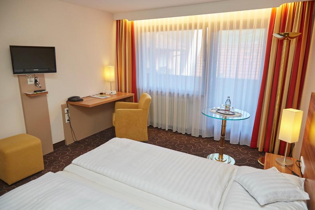 Postel nebo postele na pokoji v ubytování Flair Hotel Weinstube Lochner