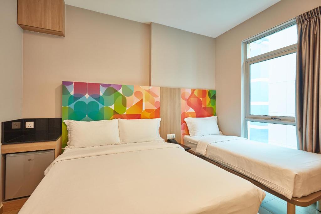 a hotel room with two beds and a window at ibis budget Singapore Clarke Quay in Singapore