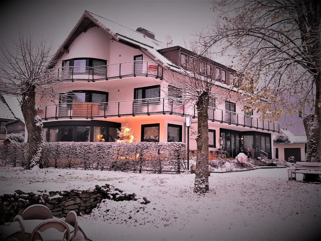 a large house with snow on the ground at Harz hotel Iris in Herzberg am Harz