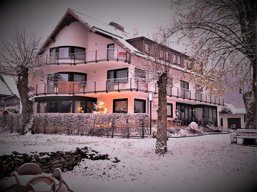ein großes Haus mit Schnee auf dem Boden in der Unterkunft Harz hotel Iris in Sieber