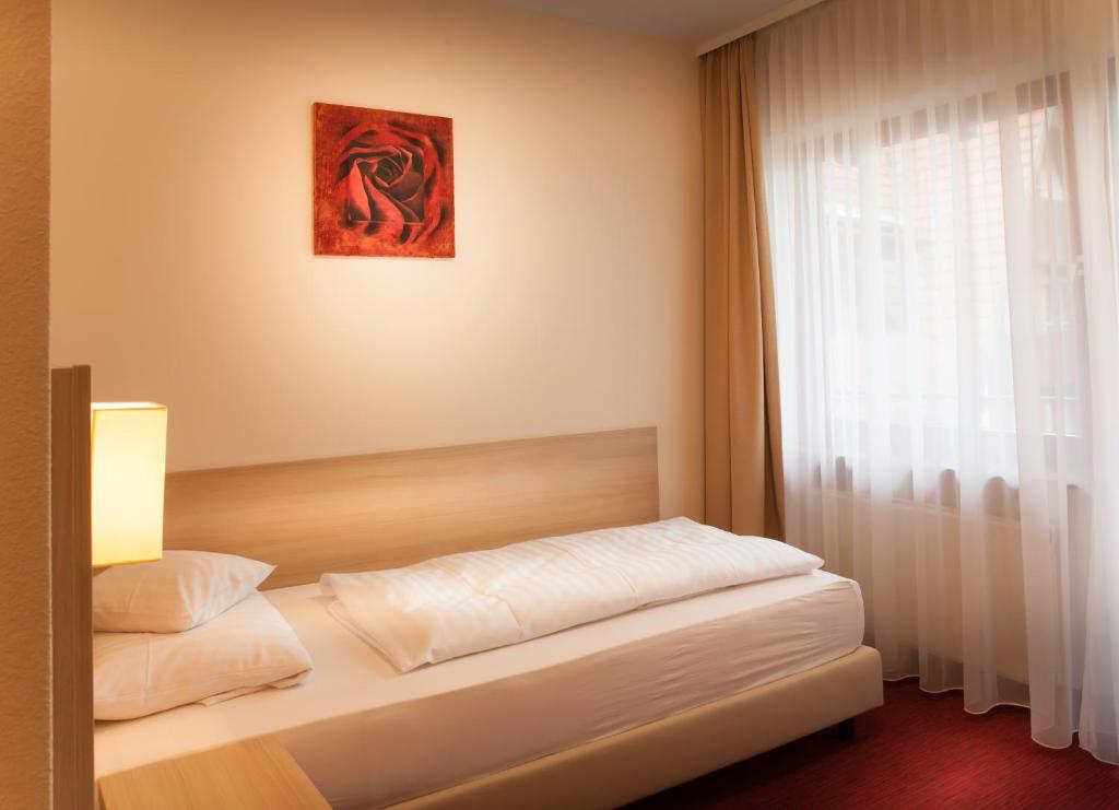 Postel nebo postele na pokoji v ubytování Flair Hotel Weinstube Lochner