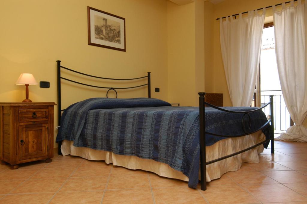 Schlafzimmer mit einem Bett mit blauer Decke in der Unterkunft L'Antipapa in Fondi