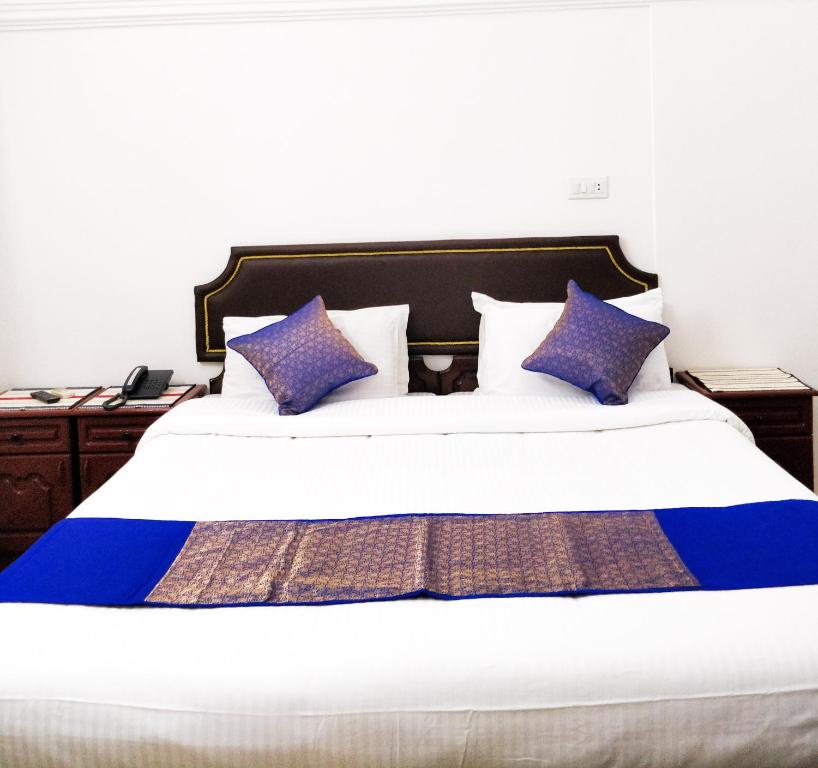 - une chambre avec un grand lit et des oreillers violets dans l'établissement Hotel JJ Inn, à Cochin