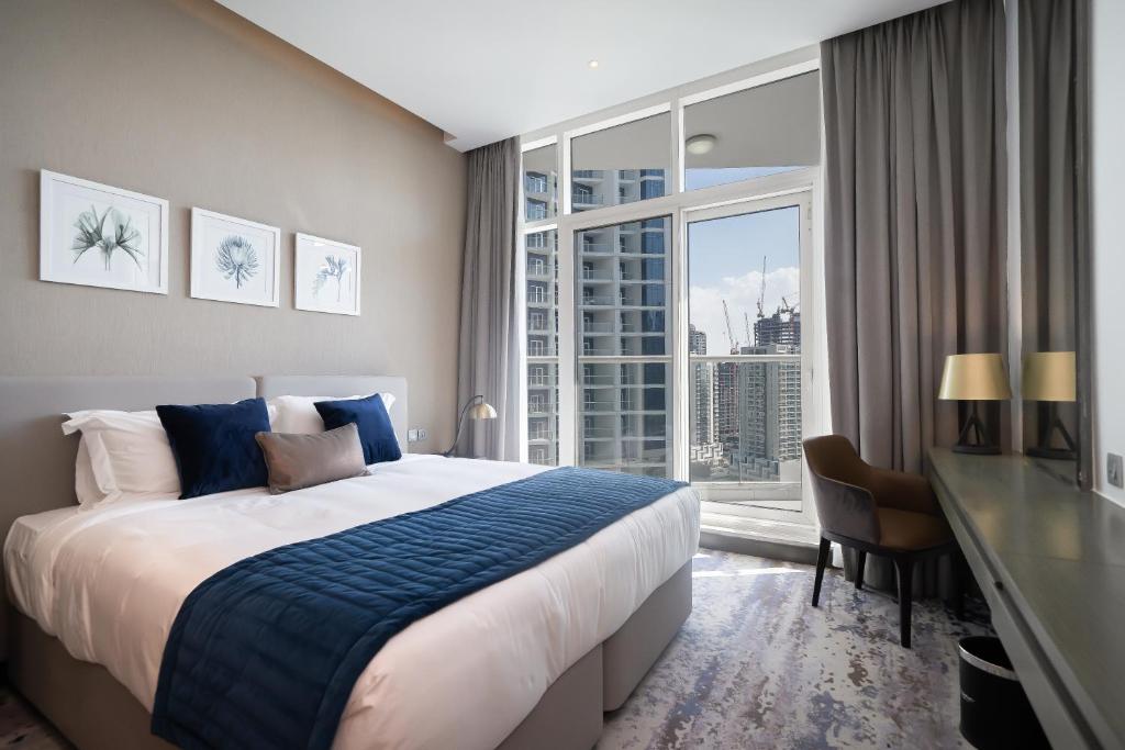 a bedroom with a large bed and a large window at Luton Vacation Homes - Damac Maison Prive Studio, Canal View, Dubai - 16AB03 in Dubai