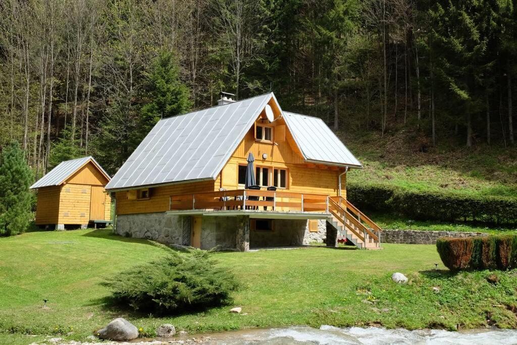 una casa de madera con techo de metal en un campo en Chata pri potoku Tále en Bystrá