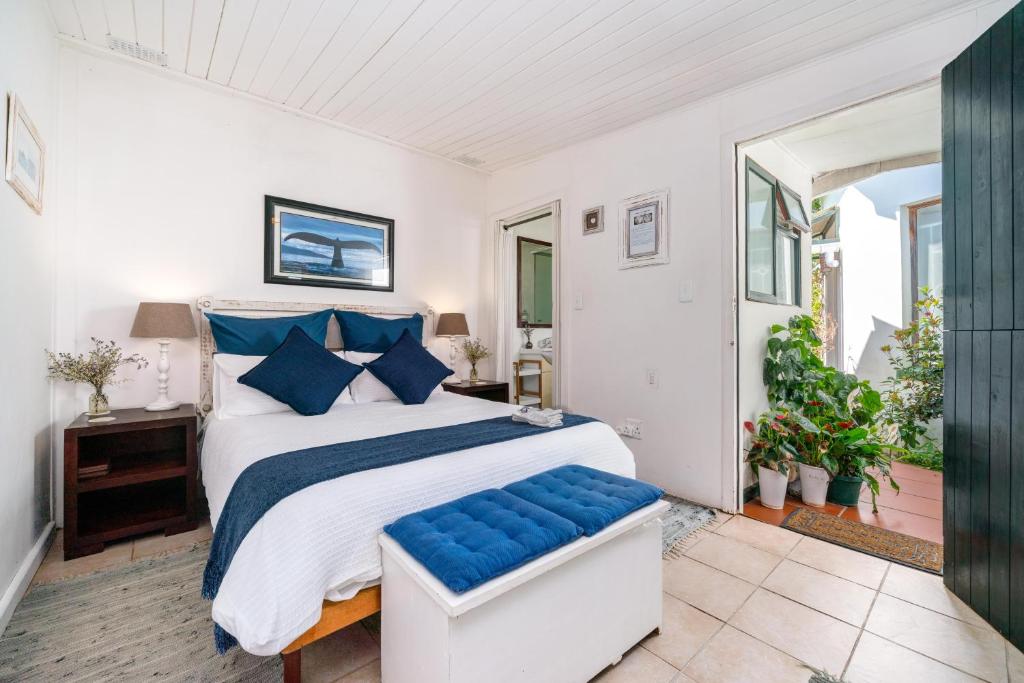 1 dormitorio con 1 cama grande con almohadas azules en O So Kozi en Keurboomstrand
