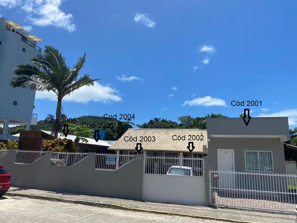 a white fence with a sign on top of a house at Bombinhas Brasil Residence Tourist Home no Centro de Bombinhas in Bombinhas