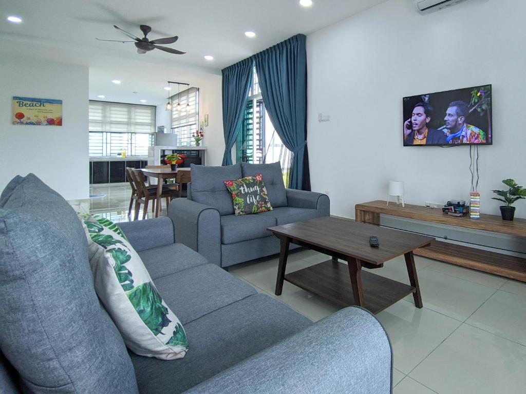 - un salon avec un canapé et une table dans l'établissement Desaru Comfy Home with Netflix Near Beach, Waterpark & BBQ, à Bandar Penawar