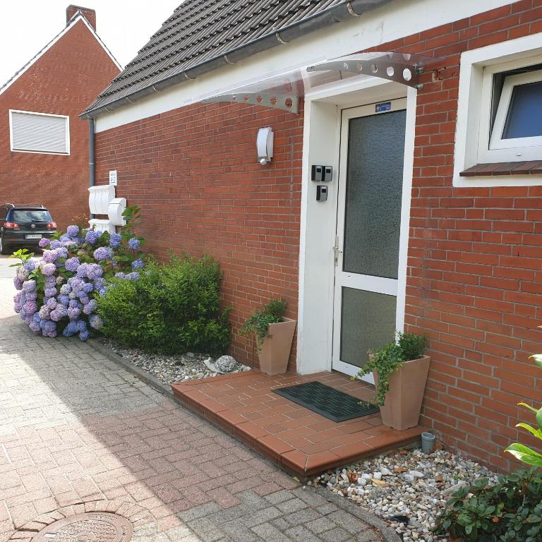 a front door of a house with purple flowers at Eden´s Ferienwohnungen in Neuharlingersiel