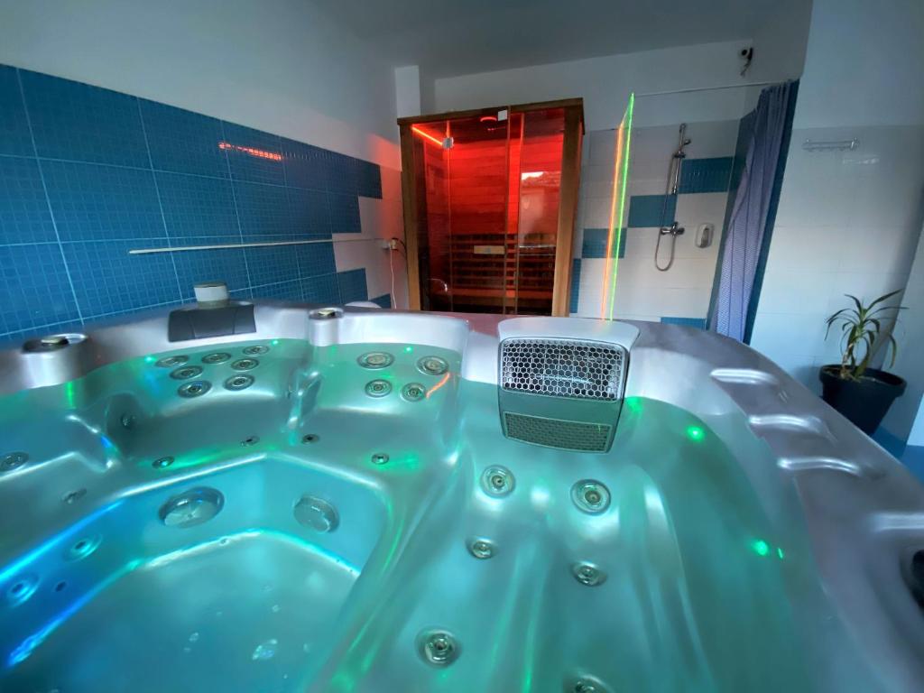 a blue tub in a bathroom with a mirror at Vila Cristal in Baile Felix