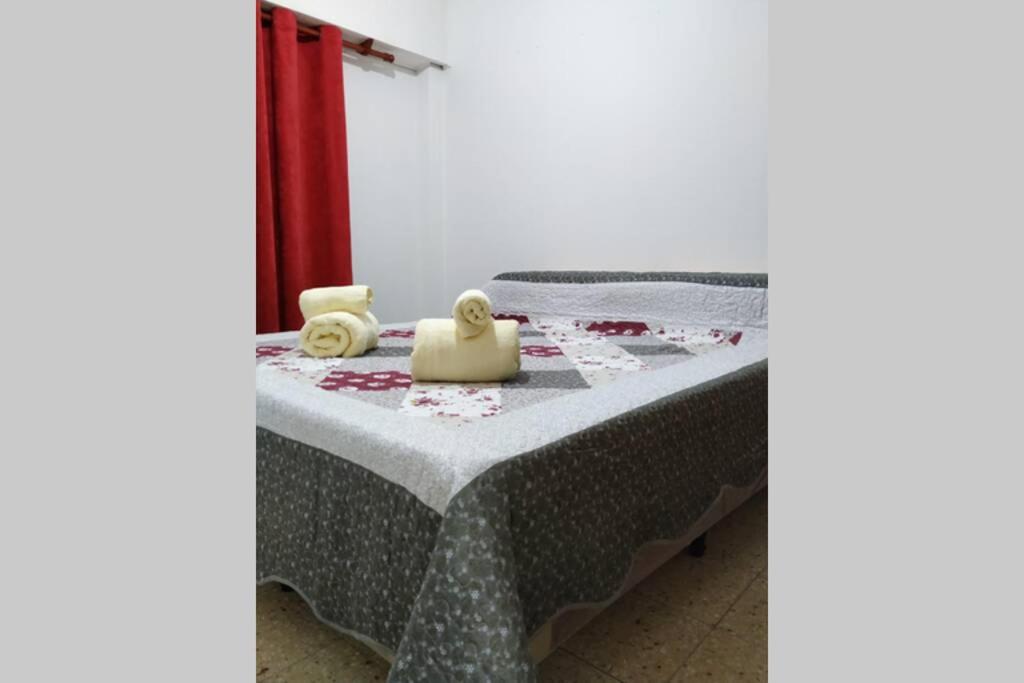 uma cama num quarto com uma mesa em Amplio dpto en el centro de Salta. em Salta