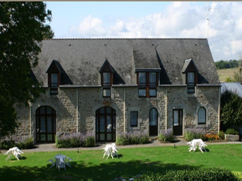 une grande maison en pierre avec quelques animaux devant elle dans l'établissement Domaine De Kerstinec/Kerland, à Riec-sur-Bélon