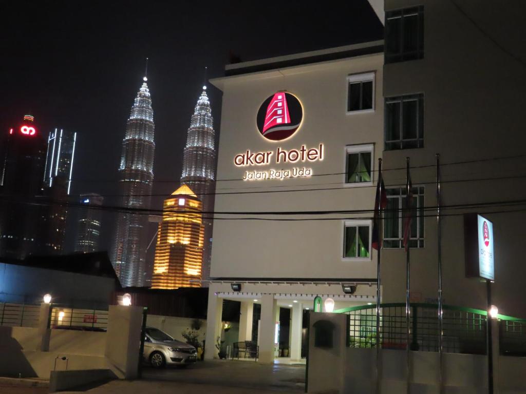 a building with the sign for a hotel with the petronas towers at Akar Hotel Kampung Baru in Kuala Lumpur