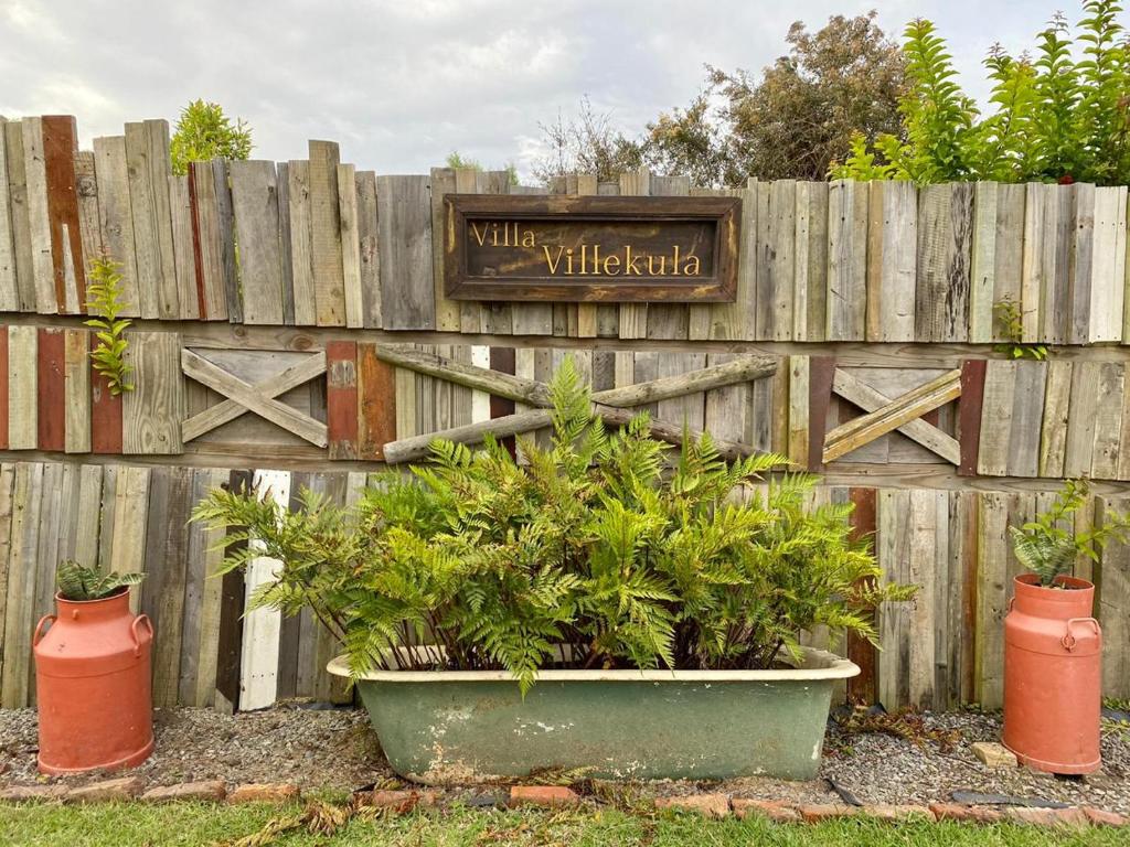 a fence with a planter with plants in front of it at ECO Lodge Villa Villekula in The Crags