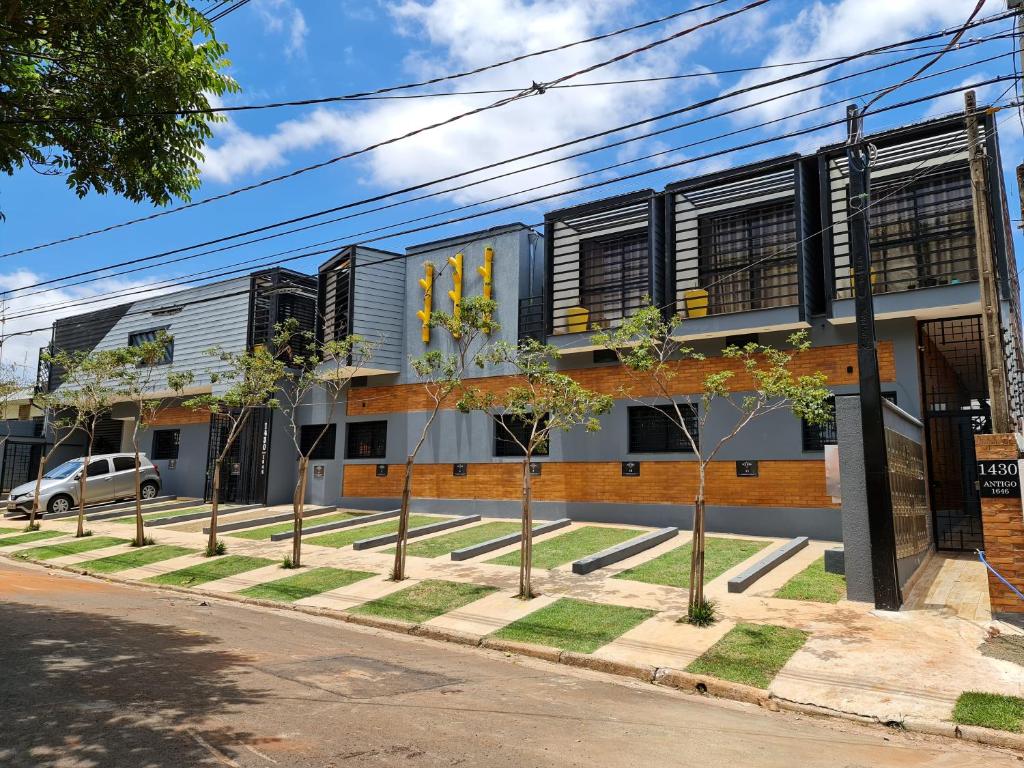 um edifício com uma fila de árvores à frente em New York City Village - Barão Geraldo - Campinas em Campinas