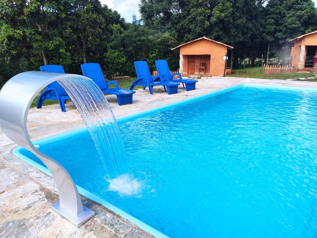 a water slide in a pool with blue chairs at Quinta do Vale in Pirenópolis