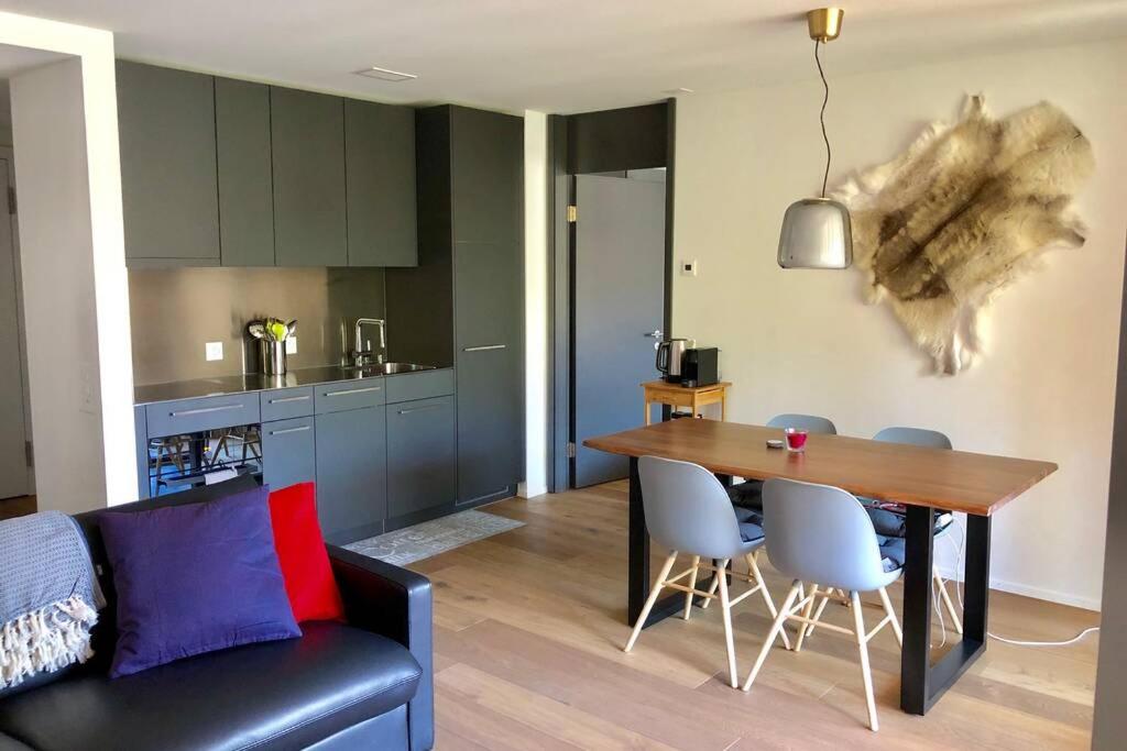 a kitchen and dining room with a table and chairs at Beautiful Sunny New 1 Bed Apt (2.5Zim). Ski in/out in Flims