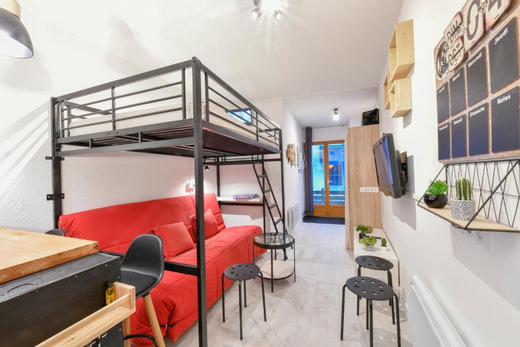 a room with a bunk bed and a red couch at Studio idéalement situé in Cauterets