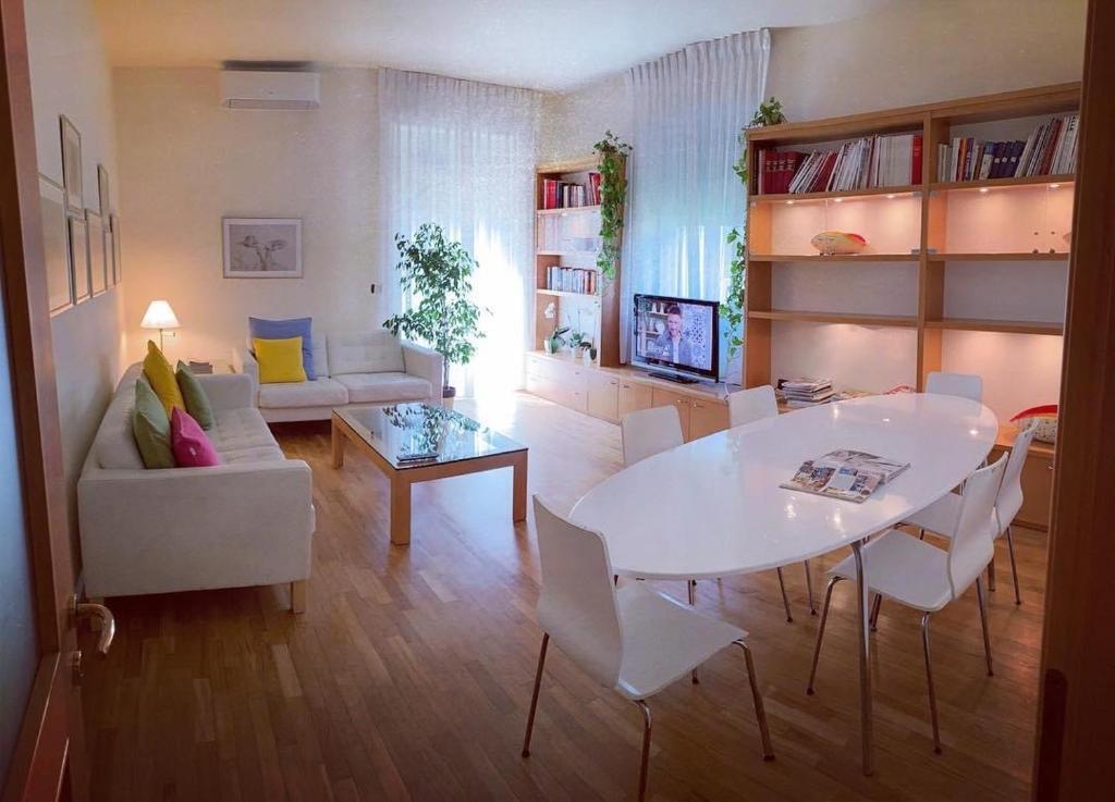 sala de estar con mesa blanca y sillas en Casa Beraldini, en Verona