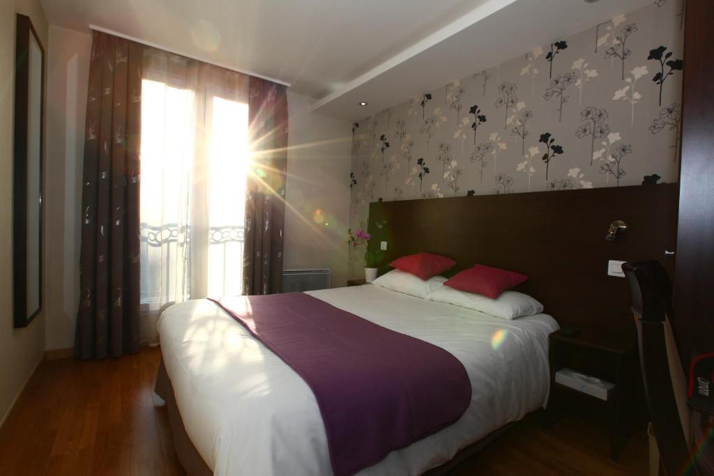 a bedroom with a large bed and a window at Hôtel Alane in Paris