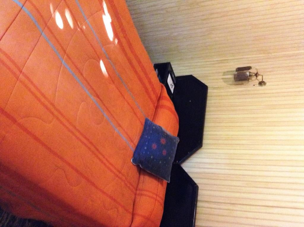 an orange bag with a tag on it on a floor at Hostel 1760 in Talca