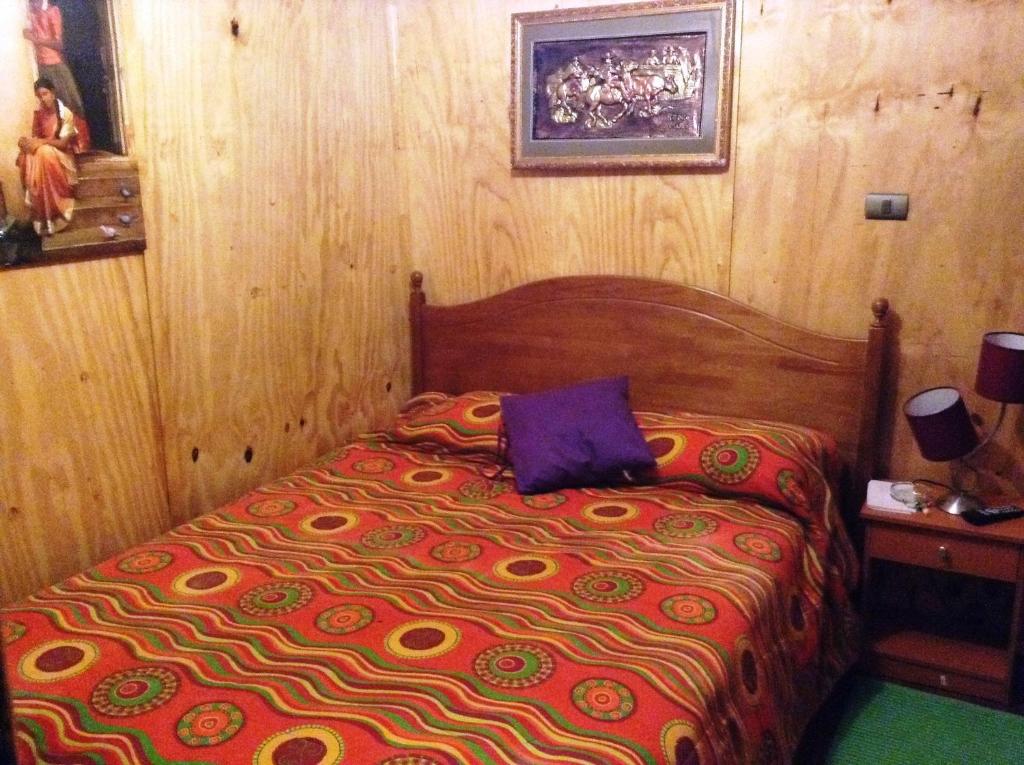 a bedroom with a bed in a wooden room at Hostel 1760 in Talca