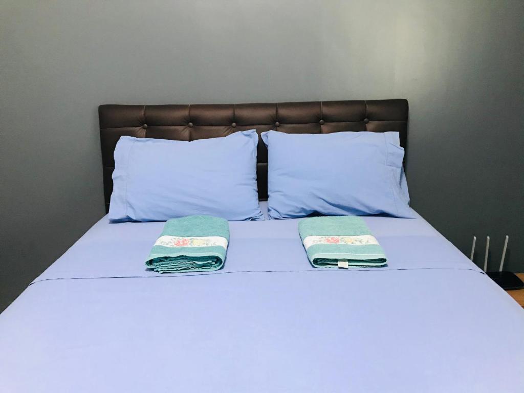 a bed with two pillows and two towels on it at Aconchego na Capital do Forró in Caruaru