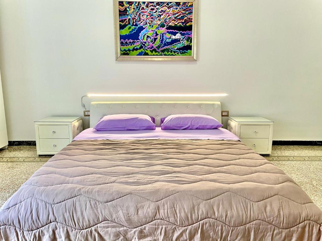 una camera da letto con un letto con cuscini viola e un dipinto di Casa Vacanze Sunshine a Salerno
