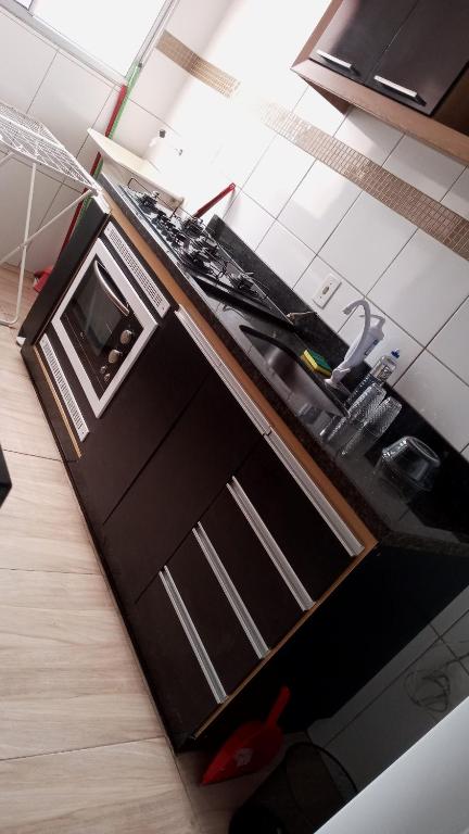 a kitchen with a sink and a stove top oven at Apartamento no val in Valparaíso de Goiás