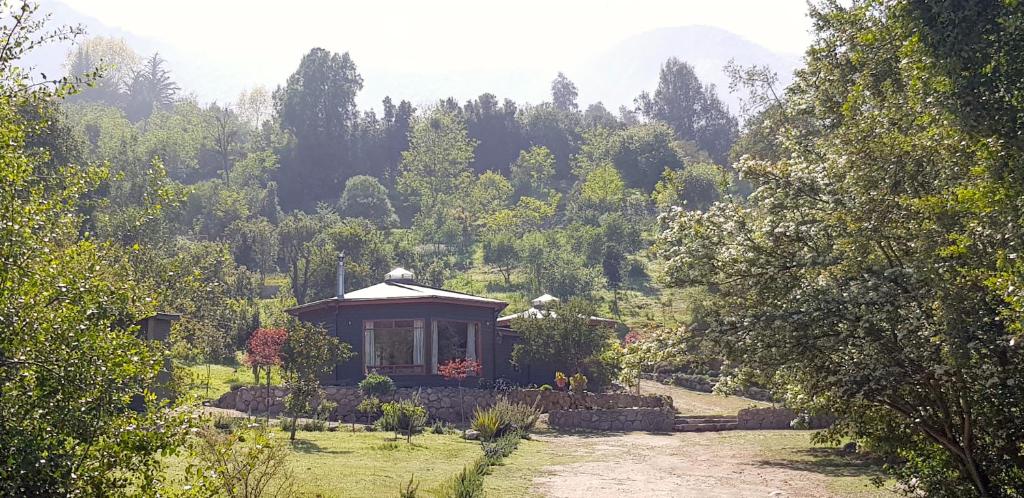 una pequeña casa en medio de un jardín en Las Palmas Lodge, en Olmué