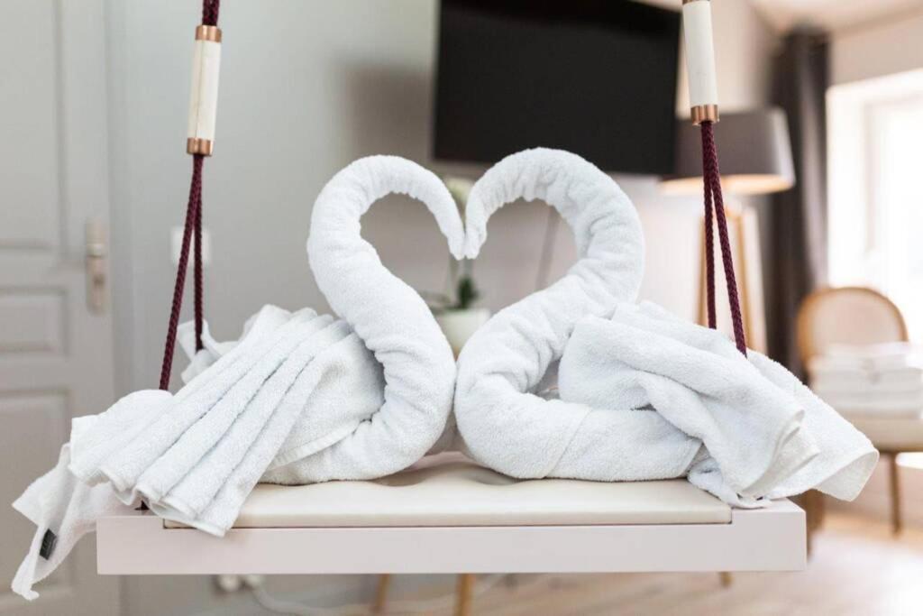 two towel swans sitting on top of a table at Suite & Spa Maison de charmes avec Sauna & Hammam in Audrieu