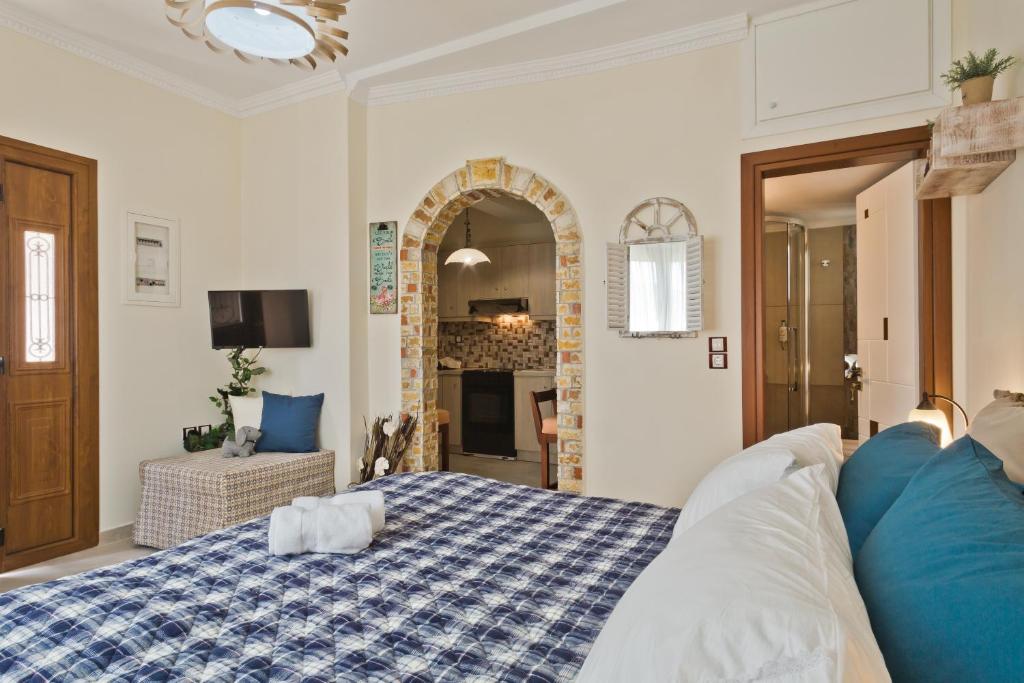 um quarto com uma cama azul e branca e uma lareira em Olive Studios Karpathos Studio #4 em Cárpatos