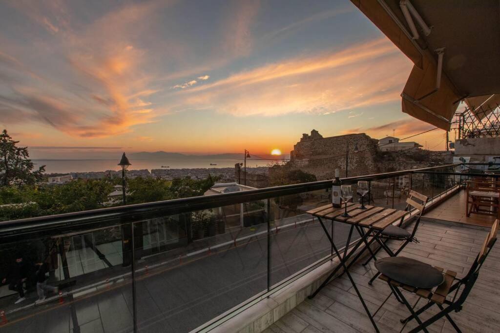 - un balcon avec une table et des chaises au coucher du soleil dans l'établissement View and the city, à Thessalonique