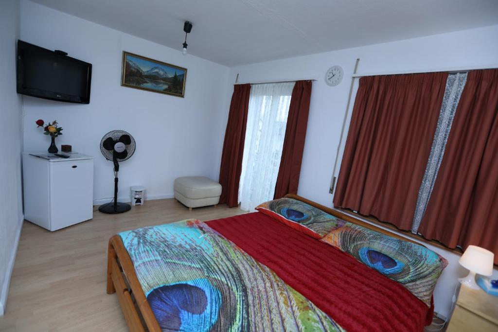 sypialnia z dużym łóżkiem z czerwonymi zasłonami w obiekcie Glatthall w mieście Opfikon