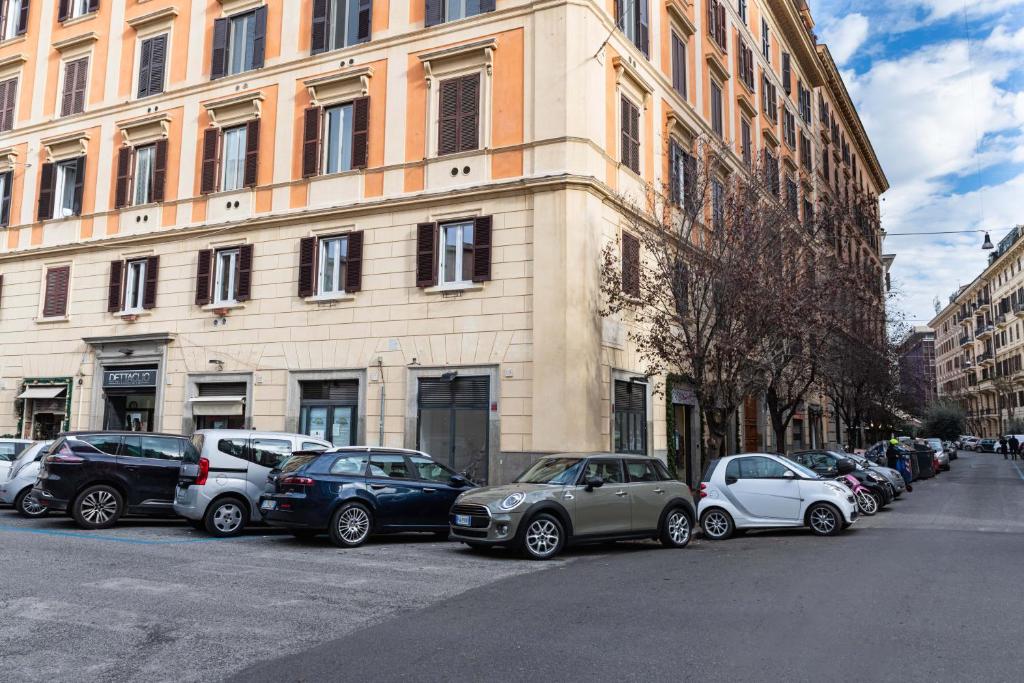 una fila di auto parcheggiate di fronte a un edificio di Casa Linnea Vacanze a Roma