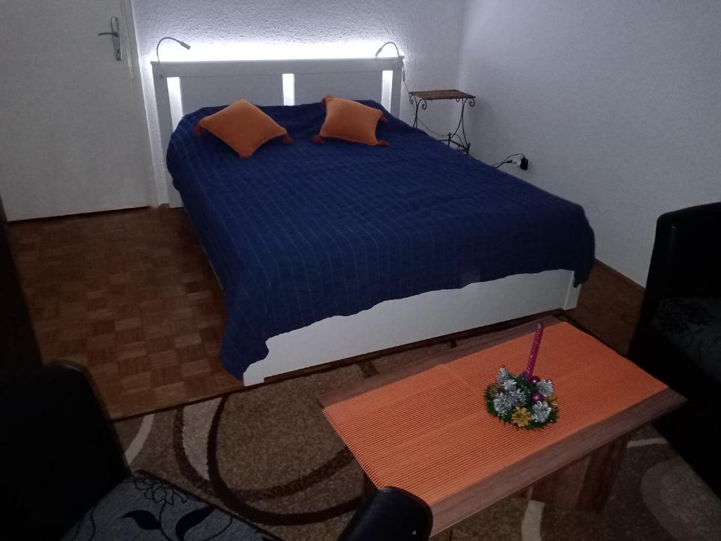 a bedroom with a bed and a wooden table at Apartman Kneginja in Trstenik