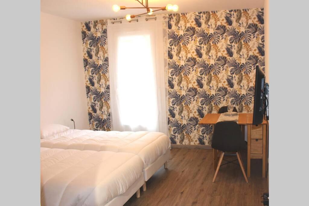una camera con letto, scrivania e finestra di Au pied des Thermes ad Amélie-les-Bains-Palalda