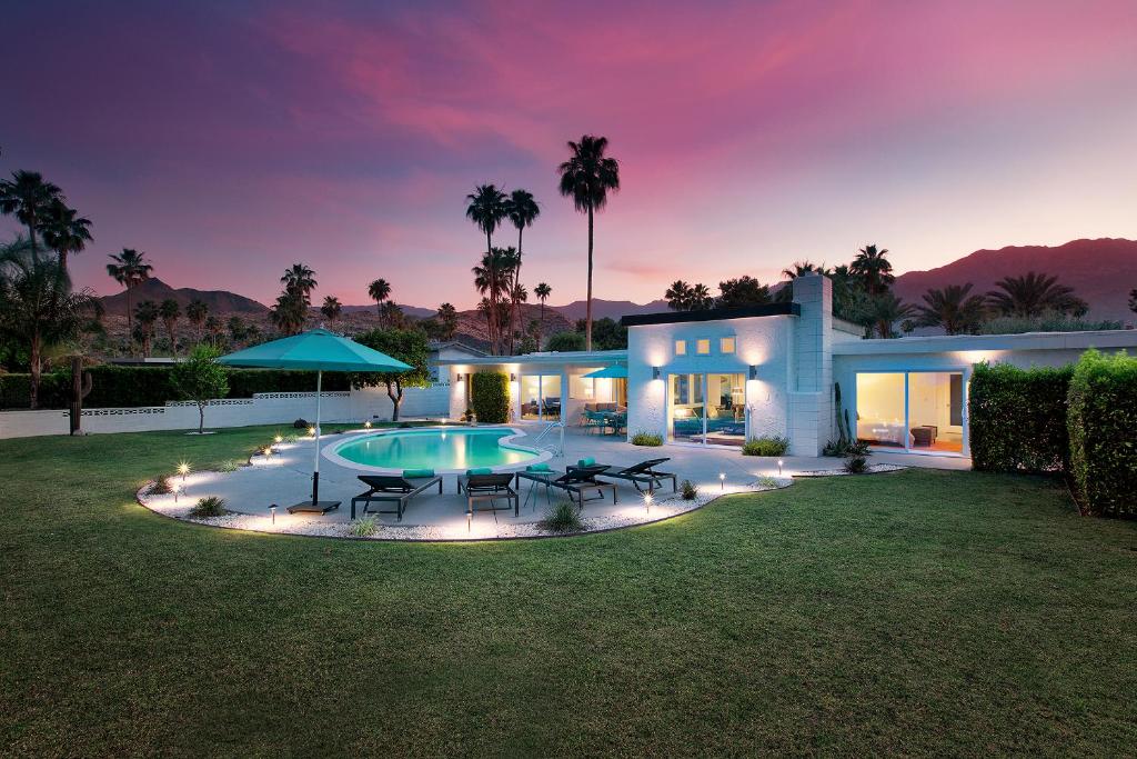 a house with a swimming pool at night at Casa Agave Palm Springs in Palm Springs
