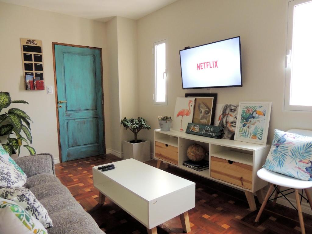 ein Wohnzimmer mit einem Sofa und einem TV in der Unterkunft Encantador Dpto, ubicación Única! Paga en pesos! in Salta