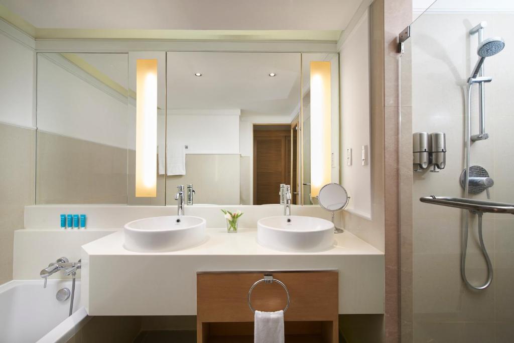 a bathroom with two sinks and a large mirror at Amari Bangkok in Bangkok
