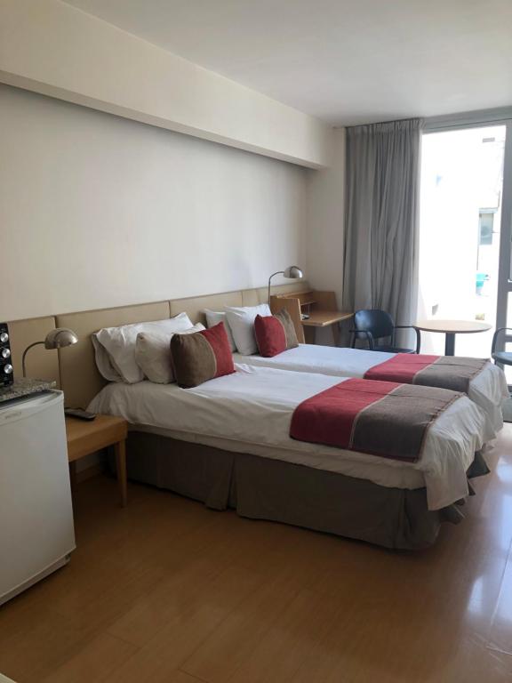 a bedroom with a large bed and a window at Design Suite Recoleta in Buenos Aires