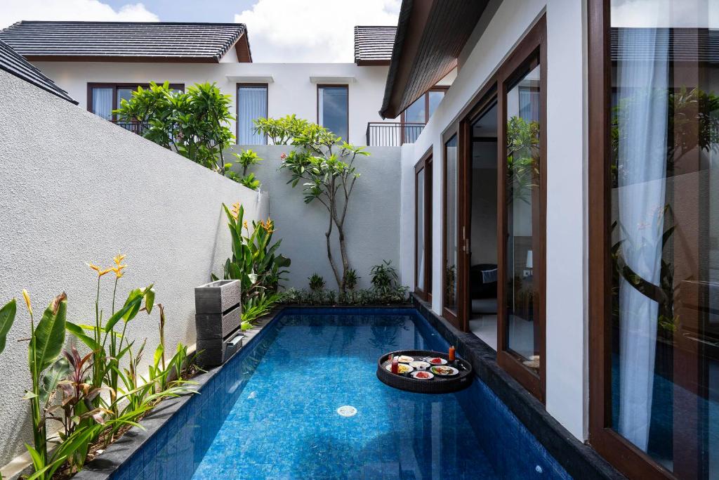 a small swimming pool in the backyard of a house at The Calna Villa Bali in Kuta