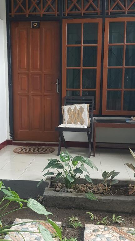 une porte d'une maison avec un banc devant elle dans l'établissement Senggigi hill view homestay, à Senggigi