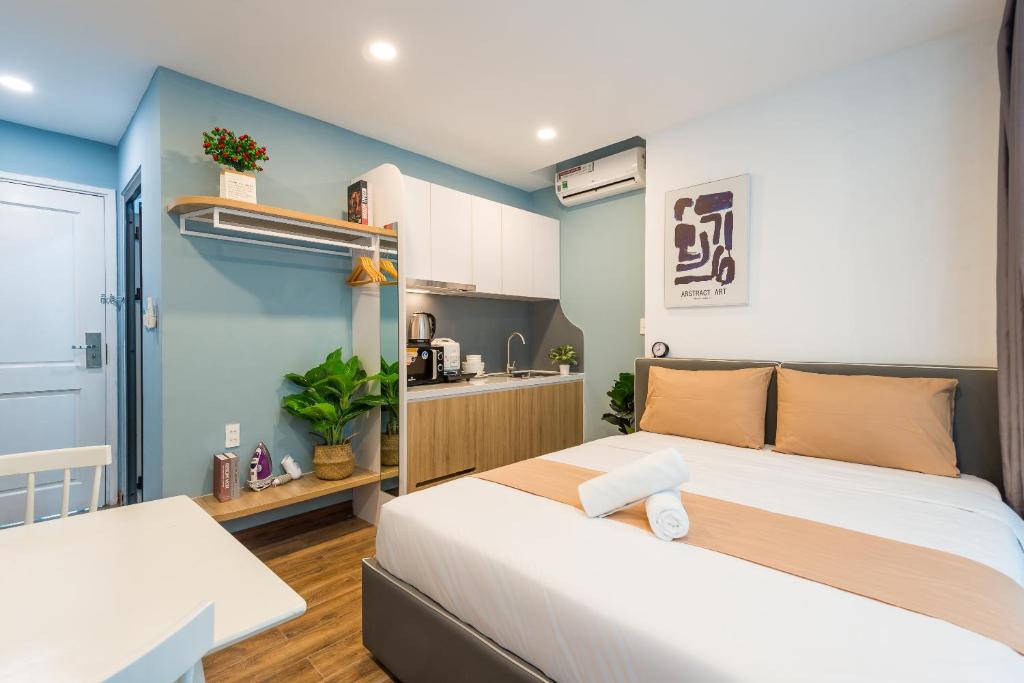 a bedroom with two beds and a kitchen at Cozrum Homes - Saphera Residence in Ho Chi Minh City