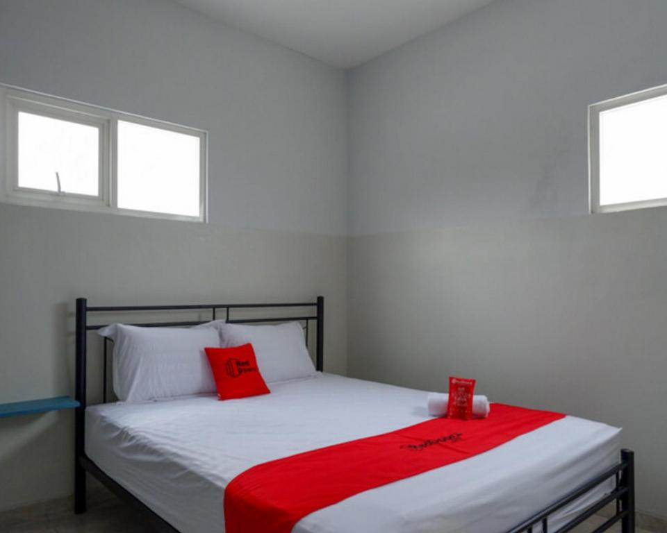 ein Schlafzimmer mit einem Bett mit zwei roten Kissen darauf in der Unterkunft RedDoorz near Tamansari Shopping Center Salatiga in Salatiga