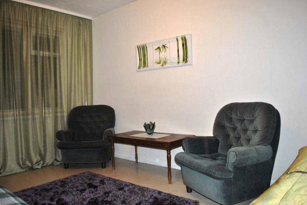 two chairs and a table in a living room at Comfort Arenda Minsk 4 in Minsk