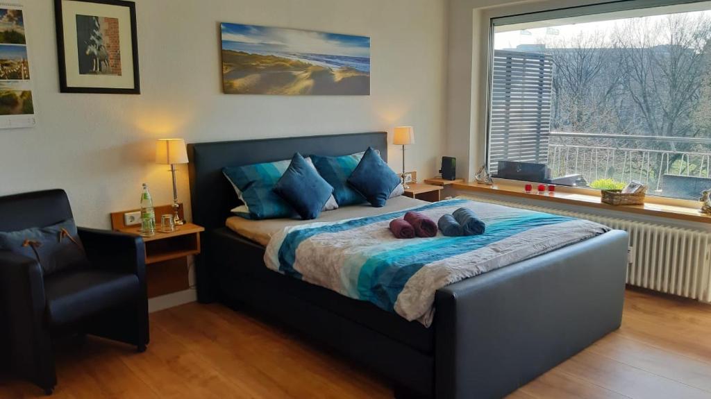 ein Schlafzimmer mit einem Bett mit blauen Kissen und einem Fenster in der Unterkunft Modern City Apartment with balcony and nice parc view in Bremen
