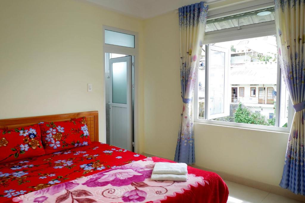 a bedroom with a red bed and a window at Tuan Vu Hai Dang Da Lat in Da Thanh